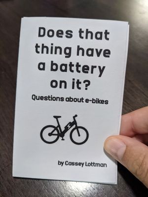the front of a small zine on white paper, which reads 'Does that thing have a battery on it? Questions about e-bikes, by Cassey Lottman